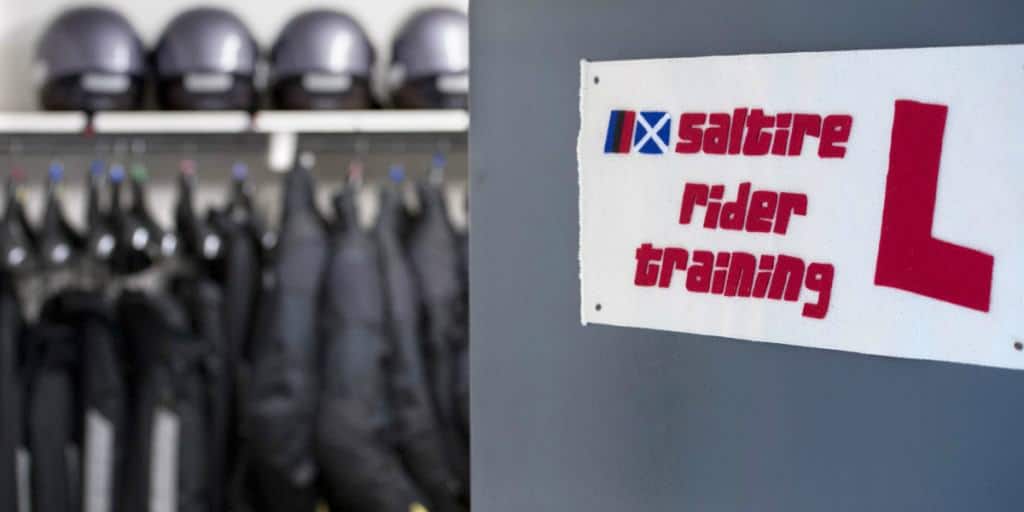Saltire rider training sign with jackets and helmets behind